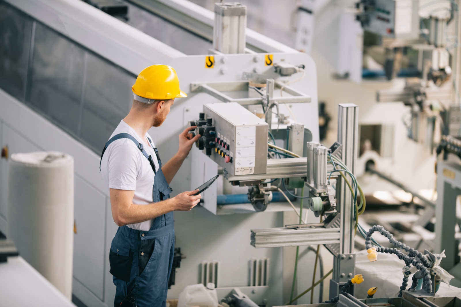Operator adjusting controls on a production machine